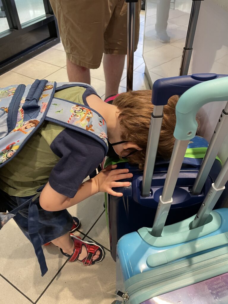 Our then 3 year old son with his face down on his suit case as if to say "What were you people thinking?!"